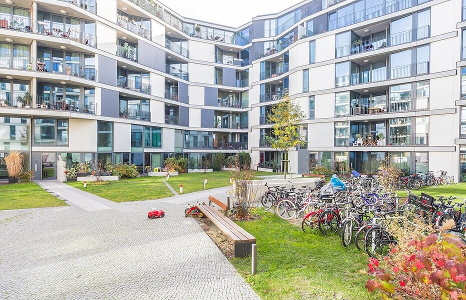 Innenhof des Wohnprojekts PolygonGarden in Berlin-Friedrichshain mit Wohnungen, Balkonen, Grünflächen und Fahrradstellplätzen