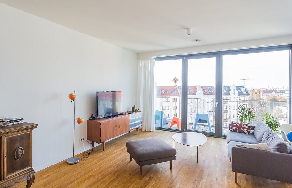 Wohnraum im Projekt PolygonGarden in Berlin-Friedrichshain mit großflächigen Fenstern, Balkon und Blick in den Stadtraum